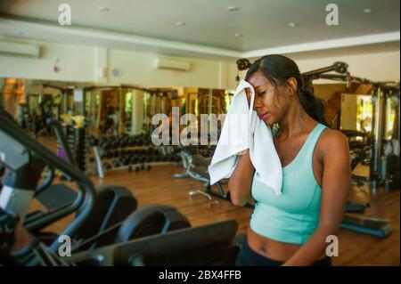 Drinnen Fitness-Studio Porträt der jungen attraktiven schwarzen African American Frau schwitzen Training hart im Fitness-Club nach Laufband Laufen Workout Wischen sw Stockfoto