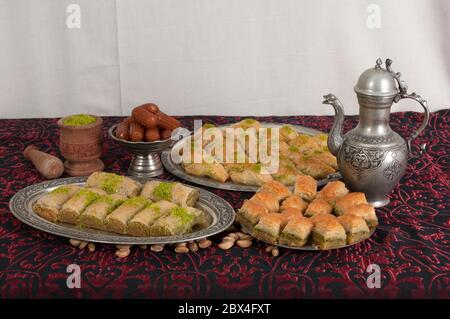 Traditionelle türkische Desserts auf einem Tisch. Baklava und Tulumba Dessert. Desserts aus Pistazien, Walnuss, Teig und Zuckersorbet. Stockfoto