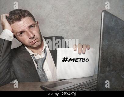 Junge depressive und frustrierte Geschäftsmann verzweifelt im Büro Computer Schreibtisch halten Notizblock mit dem Hashtag mich zu metoo als ausgebeuteten Mitarbeiter victi Stockfoto