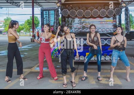 KANCHANABURI THAILAND - 1. SEPTEMBER: Nicht identifizierte weibliche Touristen tanzen vor den Bus am Parkplatz am September 1,2019 in Kanchanaburi, Thailand Stockfoto