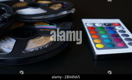 LED-Streifen Spulen Nahaufnahme. Diode mit Bedienfeld zum Umschalten der Farben auf dunklem Hintergrund. Stockfoto