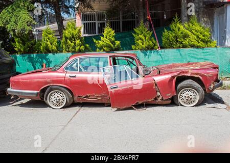 Altes Wrack zerbrochenes Auto auf der Straße Stockfoto