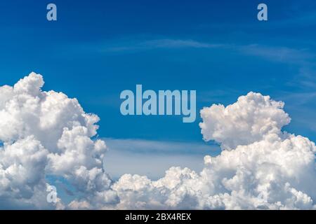 Weiße flauschige Wolken am blauen Himmel. Weiches Tragegefühl wie Baumwolle. Weiße Puffy Wolken Umhang mit Platz für Text. Schönheit in der Natur. Nahaufnahme weißer Cumulus Stockfoto