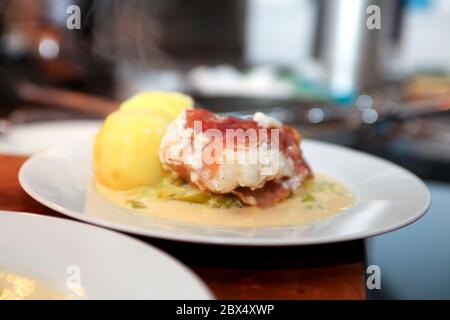 Wels und parmaschinken mit Kartoffeln und Lauch auf einem Teller in der Küche warten darauf serviert zu werden Stockfoto