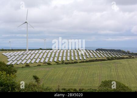 Sonnenkollektoren und Windkraftanlagen in der walisischen Landschaft pendine Carmarthenshire Wales Cymru UK Stockfoto