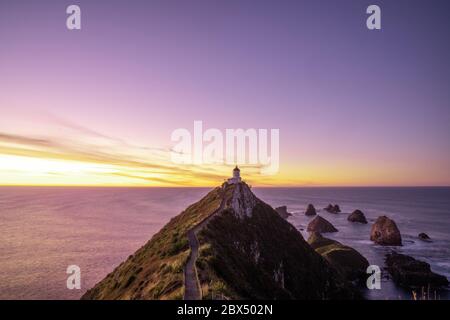 Ein Teil von Nugget Point ist eine der schönsten Landformen entlang der Küste von Otago in Neuseeland mit einem Leuchtturm und einer Streuung von felsigen Inseln. Stockfoto