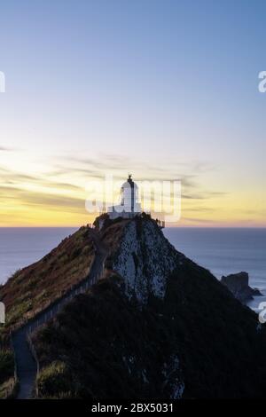 Ein Teil von Nugget Point ist eine der schönsten Landformen entlang der Küste von Otago in Neuseeland mit einem Leuchtturm und einer Streuung von felsigen Inseln. Stockfoto