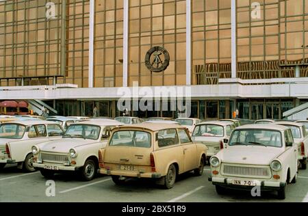 Berliner Bezirke / Ende der DDR / Emblem / 20.2.1985 Ost-Berlin: Palast der Republik. Es gab auch die Volkskammer. Das DDR-Emblem hängt noch immer dort. Der davor abgehngte Parkplatz zeigt den Wohlstand der DDR. Es gab hauptsächlich nur 2 Typen von Autos: Trabant und Wartburg. Der Palast wurde nach der Vereinigung abgerissen. // DDR-Staat / Linden anstelle des 1950 abgerissenen Stadtpalastes wurde ab 1973 das Schloss der Republik gebaut, 180 m lang, 32 m breit. Im Inneren waren verschiedene Einrichtungen. In der großen Halle, die 5000 Besucher hielt, fanden Veranstaltungen statt. Die Volkskammer der DDR Stockfoto