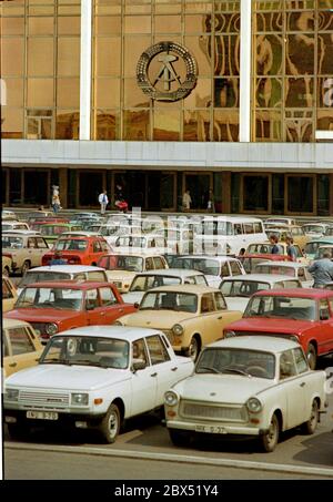 Berliner Bezirke / Ende der DDR / Emblem / 20.2.1985 Ost-Berlin: Palast der Republik. Es gab auch die Volkskammer. Das DDR-Emblem hängt noch immer dort. Der davor abgehngte Parkplatz zeigt den Wohlstand der DDR. Es gab hauptsächlich nur 2 Typen von Autos: Trabant und Wartburg. Der Palast wurde nach der Vereinigung abgerissen. // DDR-Staat / Linden anstelle des 1950 abgerissenen Stadtpalastes wurde ab 1973 das Schloss der Republik gebaut, 180 m lang, 32 m breit. Im Inneren waren verschiedene Einrichtungen. In der großen Halle, die 5000 Besucher hielt, fanden Veranstaltungen statt. Die Volkskammer der DDR Stockfoto