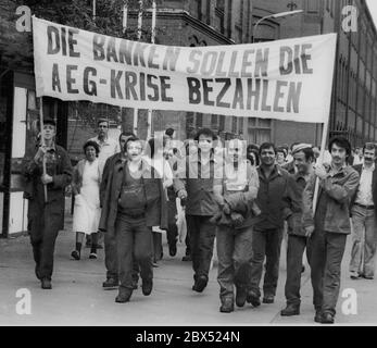 Berlin / Hochzeit / Türken / Ausländer 1983 Hochzeit: Proteste vor dem Fabriktor der AEG in der Brunnenstraße. Die AEG steht vor dem Konkurs, dieses Werk soll geschlossen werden. Die Mehrheit der Arbeitskräfte ist türkisch. Arbeiter verlassen die Fließlinien und kommen zu der Versammlung vor dem historischen Fabriktor. // Industrie / Geschichte 1888 baute AEG in Wedding an der Ackerstraße einen großen Industriekomplex, der bald zu klein wurde. Es übernahm ein noch größeres Grundstück in der Voltastraße. In den riesigen Fabriken wurde fast alles produziert, was AEG verkaufte: Kleine Motoren und riesige Turbinen, Stockfoto