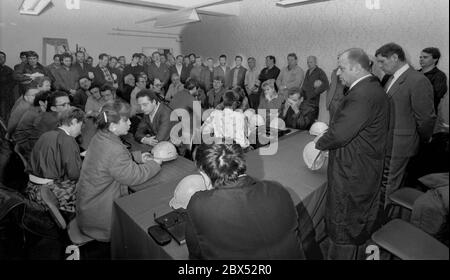 DDR-Land / Sachsen-Anhalt / Dezember 1989 Kupfer- und Silberhütte in Hettstedt. Das Geschäft gehörte zum Kombinat Mansfeld, einem Zufluchtsort unter den DDR-Betrieben. Die Mansfelder Arbeiter des Mittelalters wurden als Vorläufer des Sozialismus angesehen. DDR-Minister für Leichtindustrie Singhuber, ein Erzstalinist, wird bei der Firmenversammlung zu den Arbeitern sprechen. Er erklärte ihnen, dass die Kupfereinnahmen die Kosten nicht decken und dass die Anlage stillgelegt werden müsse. Rechts von ihm steht der Werksleiter Rost, der bei dieser Gelegenheit zum Generaldirektor ernannt wurde. Er ist immer noch Werksleiter dort Stockfoto