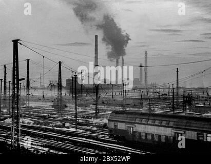 Sachsen-Anhalt / DDR Land / Winter / Dezember 1989 Winterabend in Bitterfeld, Braunkohlekombinat, Bahngelände vor // Stimmung / Wirtschaft / Vertrauen / Industrie / Landschaft 1894 die Firma Chemische Fabrik Griesheim (Frankfurt am Main) Baut in Bitterfeld eine Fabrik zur Herstellung von chloriertem Kalk durch Elektrolyse. 1900 wurde das Verfahren auch zur Gewinnung von Magnesium und Aluminium eingesetzt, 1923 zog Griesheim komplett nach Bitterfeld. In der Nähe der Braunkohlebergwerke siedelten sich weitere Firmen an: Agfa baute eine Farb- und eine Folienfabrik. 1990 kam das Ende. Das VEB Chemiekombinat hatte noch 13000 Stockfoto