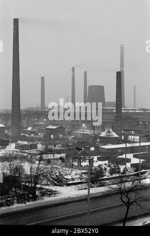 Sachsen-Anhalt / DDR Land / Winter / Dezember 1989 Winterabend in Bitterfeld, Braunkohlekombinat, Industriestandort, Ausfall-Straße // Stimmungen / Wirtschaft / Vertrauen / Industrie / Landschaft 1894 die Firma Chemische Fabrik Griesheim (Frankfurt am Main) In Bitterfeld wurde eine Fabrik zur Herstellung von chloriertem Kalk durch Elektrolyse errichtet. 1900 wurde das Verfahren auch zur Gewinnung von Magnesium und Aluminium eingesetzt, 1923 zog Griesheim komplett nach Bitterfeld. In der Nähe der Braunkohlebergwerke siedelten sich weitere Firmen an: Agfa baute eine Farb- und eine Folienfabrik. 1990 kam das Ende. Das VEB Chemiekombinat noch Stockfoto