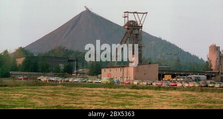 Thüringen / DDR / 8 / 1990 Uranhalden bei Ronneburg sind diese spitzen Kegelhalden lange unzugänglich. Sie sind so befestigt, dass der Regen keine radioaktiven Stoffe ins Grundwasser spült. Die Sanierung der Urandeponien wird mehr als 6 Milliarden Euro kosten. Bergbauschacht im Vordergrund, er ist noch in Betrieb / Urandeponien / Wismut / Umwelt / Kernkraft / Landschaft die deutsch-sowjetische Aktiengesellschaft wurde nach der Gründung der DDR gegründet, Damit die Sowjetunion weiterhin Zugang zum Uran im Erzgebirge hat. Von 1946 bis 1990, Stockfoto