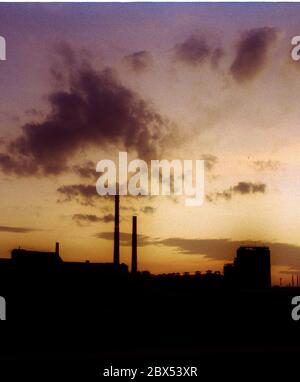 Sachsen-Anhalt / Industrie / DDR / 12/1991 Sonnenuntergang hinter dem Braunkohlekraftwerk in Bitterfeld // Energie / Umwelt / Industrielandschaft / Treuhand 1894 errichtete die Chemische Fabrik Griesheim (Frankfurt am Main) in Bitterfeld eine Fabrik zur Herstellung von chloriertem Kalk durch Elektrolyse. 1900 wurde das Verfahren auch zur Gewinnung von Magnesium und Aluminium eingesetzt, 1923 zog Griesheim komplett nach Bitterfeld. In der Nähe der Braunkohlebergwerke siedelten sich weitere Firmen an: Agfa baute eine Farb- und eine Folienfabrik. Ein großer VEB-Rohrleitungskombinat wurde ebenfalls gebaut. 1990 kam das Ende. Der VEB Stockfoto