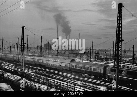 Sachsen-Anhalt / DDR / Winter / Dezember 1989 Winterabend in Bitterfeld, Sonnenuntergang hinter dem Braunkohlekombinat, Bahngelände vor // Stimmung / Wirtschaft / Vertrauen / Industrie / [automatisierte Übersetzung] Stockfoto