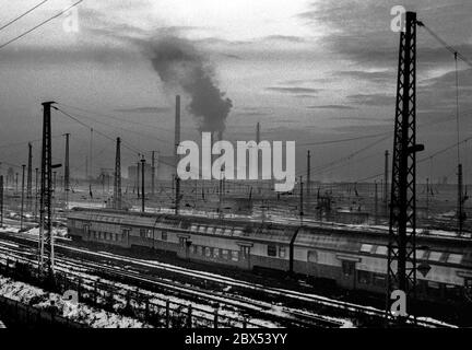Sachsen-Anhalt / DDR / Winter / Dezember 1989 Winterabend in Bitterfeld, Sonnenuntergang hinter dem Braunkohlekombinat, Bahngelände vor // Stimmung / Wirtschaft / Vertrauen / Industrie / [automatisierte Übersetzung] Stockfoto