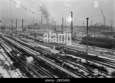 Sachsen-Anhalt / DDR / Winter / Dezember 1989 Winterabend in Bitterfeld, Sonnenuntergang hinter dem Braunkohlekombinat, Bahngelände vor // Stimmung / Wirtschaft / Vertrauen / Industrie / [automatisierte Übersetzung] Stockfoto