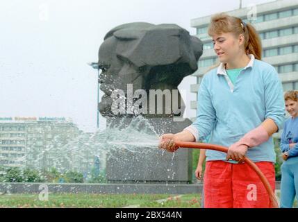 Sachsen / Chemnitz / Karl-Marx-Stadt / 1990 Karl-Marx-Denkmal des sowjetischen Bildhauers Lev Kerbel, Gärtner wässt die Blumenbeete // Sozialismus / DDR / Kommunismus / Denkmal / Geschichte / DDR-Staat / DDR-Land Stockfoto