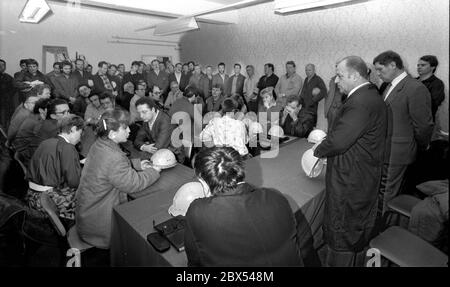 DDR / Sachsen-Anhalt / Dezember 1989 Kupfer- und Silberhütte in Hettstedt. Das Geschäft gehörte zum Kombinat Mansfeld, einem Zufluchtsort unter den DDR-Betrieben. Die Mansfelder Arbeiter des Mittelalters wurden als Vorläufer des Sozialismus angesehen. DDR-Minister für Leichtindustrie Singhuber, ein Erzstalinist, wird bei der Firmenversammlung zu den Arbeitern sprechen. Er erklärte ihnen, dass die Kupfereinnahmen die Kosten nicht decken und dass die Anlage stillgelegt werden müsse. Rechts von ihm steht der Werksleiter Rost, der bei dieser Gelegenheit zum Generaldirektor ernannt wurde. Er ist dort noch 2005 Werksleiter, aber Stockfoto