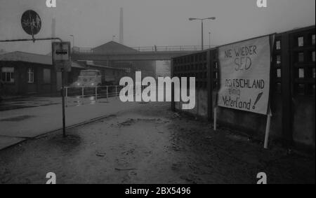 DDR-Land / Sachsen-Anhalt / Dezember 1989 Chemiekombinat in Bitterfeld. Auf dem riesigen heruntergekommenen Firmengelände hat jemand ein Schild an die Wand gehängt: -Never again SED, Germany united Fatherland- // Treuhand 1894 baut die Firma Chemische Fabrik Griesheim (Frankfurt am Main) in Bitterfeld eine Fabrik zur Herstellung von chloriertem Kalk durch Elektrolyse. 1900 wurde das Verfahren auch zur Gewinnung von Magnesium und Aluminium eingesetzt, 1923 zog Griesheim komplett nach Bitterfeld. In der Nähe der Braunkohlebergwerke siedelten sich weitere Firmen an: Agfa baute eine Farb- und eine Folienfabrik. Ein großer VEB-Rohrleitungskombinat war Stockfoto