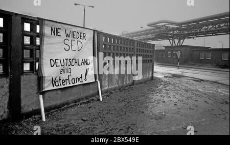 DDR-Land / Sachsen-Anhalt / Dezember 1989 Chemiekombinat in Bitterfeld. Auf dem riesigen heruntergekommenen Firmengelände hat jemand ein Schild an die Wand gehängt: -Never again SED, Germany united Fatherland- // Treuhand 1894 baut die Firma Chemische Fabrik Griesheim (Frankfurt am Main) in Bitterfeld eine Fabrik zur Herstellung von chloriertem Kalk durch Elektrolyse. 1900 wurde das Verfahren auch zur Gewinnung von Magnesium und Aluminium eingesetzt, 1923 zog Griesheim komplett nach Bitterfeld. In der Nähe der Braunkohlebergwerke siedelten sich weitere Firmen an: Agfa baute eine Farb- und eine Folienfabrik. Ein großer VEB-Rohrleitungskombinat war Stockfoto