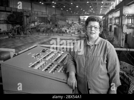 Ende der DDR / Sachsen-Anhalt / Metall-Industrie VEB Rohrleitungs-Kombinat in Bitterfeld, Werk Muldenstein, Dezember 1989: Das moderne Werk produzierte Großrohre und wurde später von Mannesmann übernommen. Frau am Maschinenstand // Treuhand / Frauen / die Firma Chemische Fabrik Griesheim (Frankfurt am Main) in Bitterfeld hat 1894 eine Fabrik zur Herstellung von chloriertem Kalk durch Elektrolyse errichtet. 1900 wurden auch Magnesium und Aluminium auf diesem Weg gewonnen, 1923 zog Griesheim komplett nach Bitterfeld. In der Nähe der Braunkohlebergwerke siedelten sich weitere Firmen an: Agfa baute Stockfoto