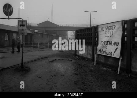 DDR-Land / Sachsen-Anhalt / Dezember 1989 Chemiekombinat in Bitterfeld. Auf dem riesigen heruntergekommenen Firmengelände hat jemand ein Schild an die Wand gehängt: -Never again SED, Germany united Fatherland- // Treuhand 1894 baut die Firma Chemische Fabrik Griesheim (Frankfurt am Main) in Bitterfeld eine Fabrik zur Herstellung von chloriertem Kalk durch Elektrolyse. 1900 wurde das Verfahren auch zur Gewinnung von Magnesium und Aluminium eingesetzt, 1923 zog Griesheim komplett nach Bitterfeld. In der Nähe der Braunkohlebergwerke siedelten sich weitere Firmen an: Agfa baute eine Farb- und eine Folienfabrik. Ein großer VEB-Rohrleitungskombinat war Stockfoto
