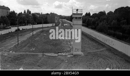 Berlin-Bezirk / DDR / 1990 Kreuzberg / Treptow: Die Wachtürme an der Berliner Mauer sind bereits verlassen, aber das Mauersystem ist noch immer deutlich sichtbar. Links der Zaun in Ost-Berlin, der Patrouillenweg für die Soldaten, der Hundelauf, der Wachturm mit Suchscheinwerfer, rechts die eigentliche Mauer nach Kreuzberg. // Grenze / Geschichte / Kommunismus [automatisierte Übersetzung] Stockfoto