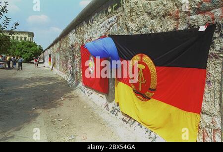 Berliner Bezirke / Kreuzberg / DDR / 11 /1989 Kreuzberg, Zimmerstraße: Troedler verkauft Mauerstücke als Souvenirs. Die Wand ist bereits sehr zerschlagen und voller Löcher, die von den Wandspechten geschnitten werden. Vor einer DDR-Flagge. Ende der DDR, Ende der Mauer // Berliner Mauer / Geschichte / Kommunismus / [automatisierte Übersetzung] Stockfoto