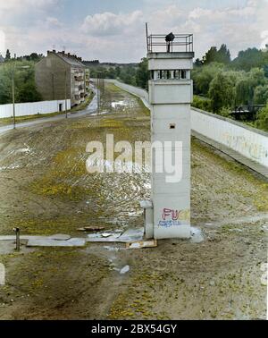 Berlin-Bezirk / DDR / 1990 Kreuzberg / Treptow: Die Wachtürme an der Berliner Mauer sind bereits verlassen, aber das Mauersystem ist noch immer deutlich sichtbar. Links der Zaun in Ost-Berlin, der Patrouillenweg für die Soldaten, der Hundelauf, der Wachturm mit Suchscheinwerfer, rechts die eigentliche Mauer nach Kreuzberg. // Grenze / Geschichte / Kommunismus [automatisierte Übersetzung] Stockfoto