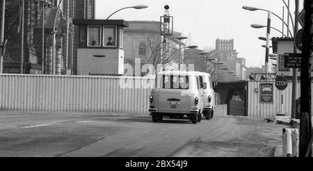 Berlin-Bezirk / Mitte /Tiergarten / 3 / 1986 Grenzübergang Invalidenstraße, zwei DDR-Busse fahren zurück nach Ost-Berlin. Sie transportieren DDR-Beschäftigte, die Pässe in West-Berlin ausstellen, zu Besuchen in Ost-Berlin. Hinter dem schmalen Durchgang durch die Mauer befindet sich auf der linken Seite das Regierungspital, das heute das Bundesministerium für Wirtschaft ist. // DDR / Sozialismus / // Vereinigung / Grenze / Todesstreifen / Bezirke / DDR // DDR [automatisierte Übersetzung] Stockfoto