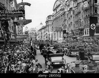 Adolf Hitler steht im ersten Auto bei seiner Ankunft in Wien. Er kündigt die Annexion Österreichs an das Deutsche Reich in Wien an. Stockfoto