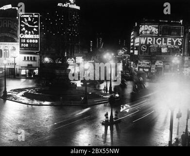 Nachtaufnahme des Picadilly Circus in London bereits teilweise verdunkelt. Die vollständige Verdunkelung beginnt um 00:30 Uhr. Stockfoto