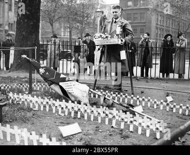 Ein einbeiniger Verkäufer von Erinnerungsmohnblumen erinnert an die Gefallenen des Ersten Weltkriegs am Waffenstillstandstag im 'Field of Remembrance' in der Westminster Abbey. Stockfoto