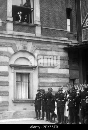 Adolf Hitler erscheint am Fenster des Festspielhauses. Vor dem Fenster halten Soldaten die jubelnden Gäste des Festivals in Schach. Stockfoto