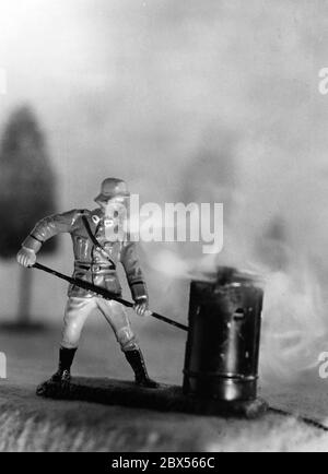 Elastolin Figur von der Firma 'O. & M. Hausser': Ein Soldat feuert eine Nebelmaschine an. Stockfoto