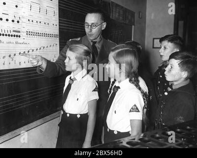 Sänger des Mozart-Chors der HJ in der Mittelschule Berlin-Weißensee müssen ihrem Lehrer an der Tafel beweisen, dass sie die Noten richtig lesen und schreiben können. Stockfoto