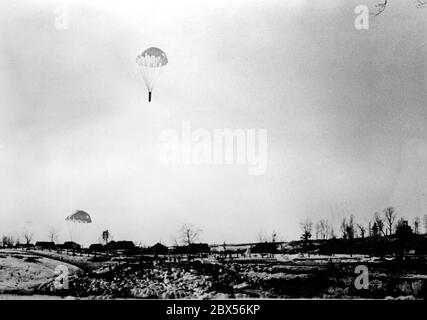 Die eingeschlossenen Soldaten der Wehrmacht in Kholm erhalten Abwürfe. Sie werden in der umzingelten Stadt mit Munition, Waffen, Ausrüstung und Lebensmitteln versorgt. Während der Kholm Pocket verteidigte die Kampfgruppe Scherer die Stadt erfolgreich für 105 Tage. (Ein Foto der PK (Propaganda Company) des Kriegsberichterstatters Richard Muck, der Anfang März in die Tasche flog). Stockfoto