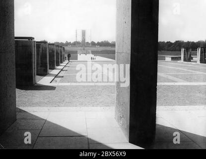 Blick von der Ehrenhalle auf das Rurum der Luitpold Arena auf dem Nürnberger Festgelände. Über der Tribüne hängt eine Hakenkreuzfahne. Ein breiter Granitweg führt direkt von der Ehrenhalle zur Tribüne. Stockfoto