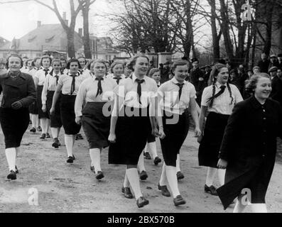 Eine Gruppe deutscher Mädchen marschiert in Kaesmark in die Turnhalle. Im Hintergrund ist ein Junge mit Hakenkreuzarmband. Stockfoto