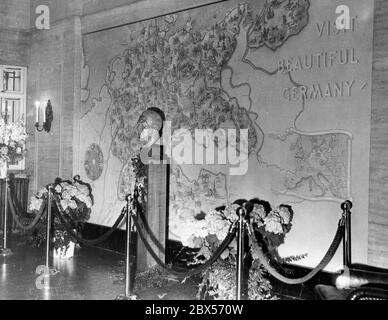 Mit einer feierlichen Zeremonie wird in New York ein Reisebüro des Deutschen Reiches eröffnet. Hier im Raum der Deutschen Reichsbahn befindet sich eine große Wandkarte des Reiches (zwischen einer Kompassrose links und einer kleinen Europakarte rechts) und eine Büste von Adolf Hitler. Auf der Karte ist die Einladung 'Visit Beautiful Germany' zu sehen. Stockfoto