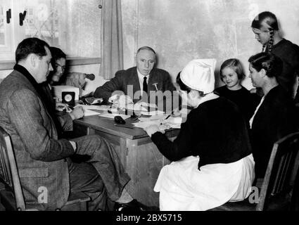 Prof. Dr. Peter Muehlens (Mitte) vom Tropical Institute Hamburg berät die 462 Deutschen, die von England aus dem ehemaligen deutschen Ostafrika vertrieben wurden. Das Bild zeigt eine Familie mit Kindern in Muehlens' Klinik, wo auch eine Krankenschwester anwesend ist. Stockfoto