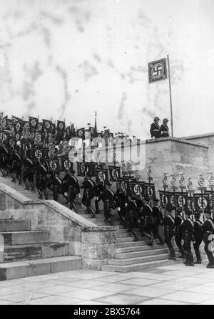 Die Träger der SS marschieren während des Grand Roll Calls in der Luitpold Arena die Stufen zum Podest hinauf. Stockfoto