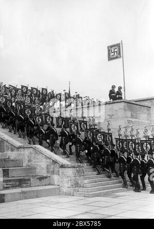 Während des Reichsparteikongresses der Arbeit findet in der Nürnberger Luitpold Arena auf dem Reichsparteitagsgelände ein großer Appell statt, wo die Standardträger der SS das Podium hochmarschieren. Stockfoto