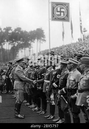 Bei den Feierlichkeiten zur Eröffnung der Nazi-Kampfspiele und der Grundsteinlegung für das Deutsche Stadion auf dem Reichsparteigelände begrüßt Adolf Hitler die Ehrengäste mit einem Händedruck, darunter auch Reichsarbeitsführer Konstantin Hierl, Reichssportleiter Hans von Tschammer und Osten, Generalleutnant Friedrich Christiansen, Reichskinder Baldur von Schirach, Korpsführer Adolf Huehnlein, Reichssouverneur Franz Ritter von Epp, Reichskapiteur Franz Xaver Schwarz. Stockfoto