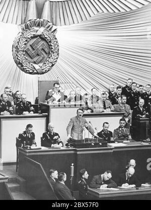 Reichstagssitzung am 18.03.1938 in der Berliner Kroll-Oper während der Rede Adolf Hitlers. Hinter Hitler am Schreibtisch des Reichstagsvorsitzenden Hermann Göring. Links sitzend, von links nach rechts: Wilhelm Brückner und Hans-Heinrich Lammers. Stockfoto