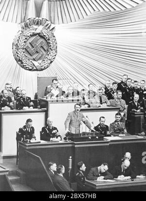 Adolf Hitler während seiner Rede bei einer Reichstagssitzung in der Berliner Kroll-Oper. Hinter ihm sitzt Hermann Göring am Schreibtisch des Reichstagspräsidenten. Stockfoto