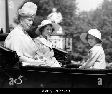 Von rechts nach links: Königin Mutter Maria, Prinzessin Elisabeth und Prinzessin Margaret Rose in der Kutsche auf dem Weg zur "Trooping der Farben"-Zeremonie in der Hausgarde-Parade. Sie wurden von einem Leibwächter begleitet. Stockfoto