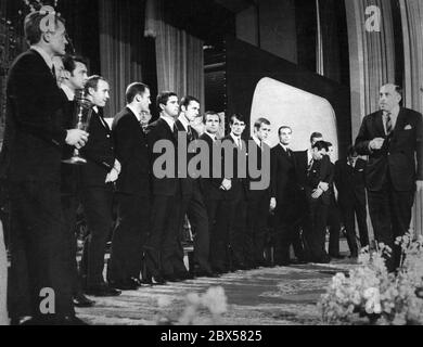 Der Fußballverein FC Bayern München, Sieger des Europapokal-Pokalsiegers 1967, wirkt elegant in einem Fernsehauftritt gekleidet. Rechts der Bundesminister für Post und Telekommunikation, Werner Dollinger. Vorne links im Bild, Mannschaftskapitän Werner Olk, daneben Trainer Zlatko Cajkovski, weiter unter den Spielern Gerd Müller (6. V.l.), Franz Beckenbauer (7. V.l.), Georg Schwarzenbeck (4. V.r., halb versteckt) und Sepp Maier (2. V.r., Blick nach unten). Stockfoto